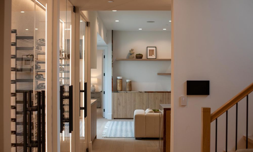 Wall-mounted tablet and smart switch near a staircase in a modern hallway
