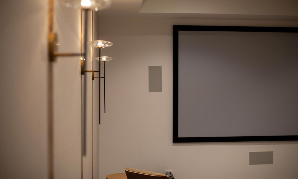 Angle view of theater sconces and large screen with neutral walls