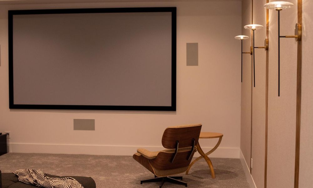 Home theater with modern wall sconces and a large projection screen
