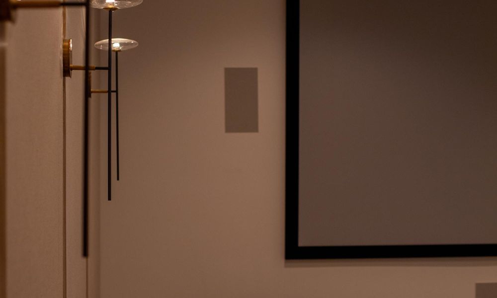 Side view of home theater with decorative sconces and armchair